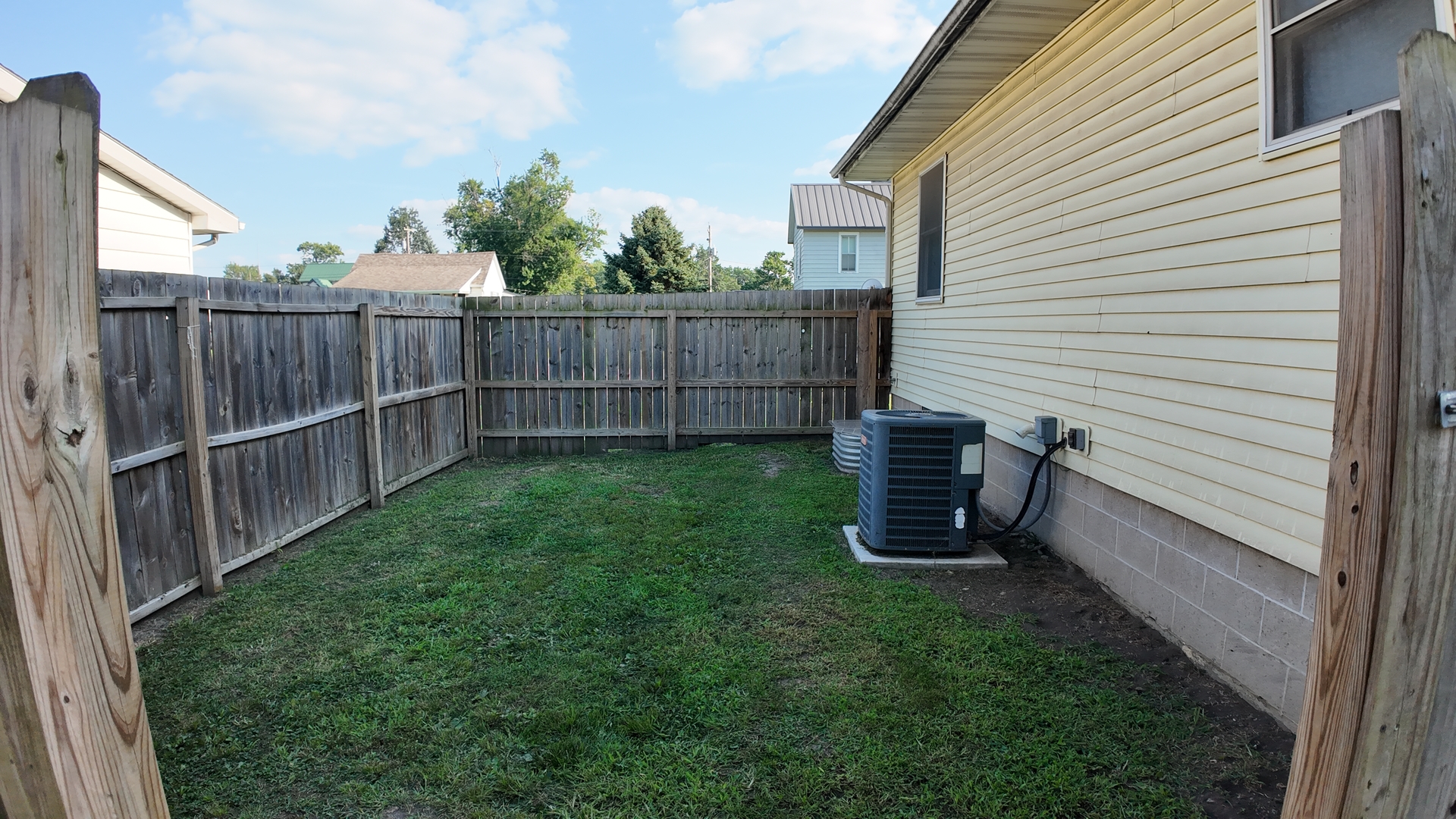 601 East Webster Street Clinton, IL 61727 - Photo 18 of 21 a view of a backyard with wooden fence and a floor to ceiling window