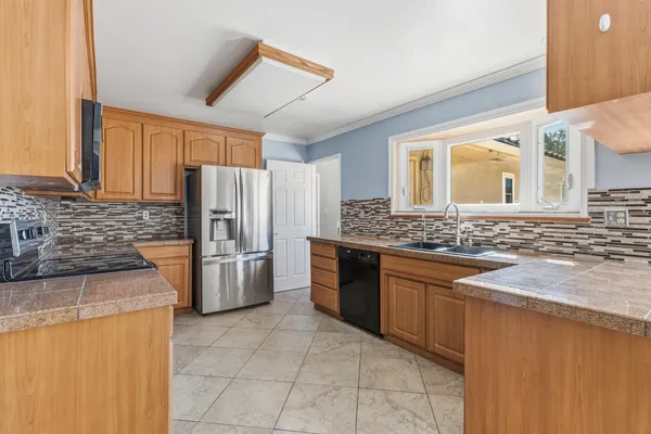 a kitchen with stainless steel appliances granite countertop a stove microwave and sink