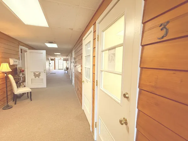 a view of a hallway with furniture and a large window