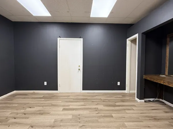 a view of a livingroom with wooden floor and bathroom