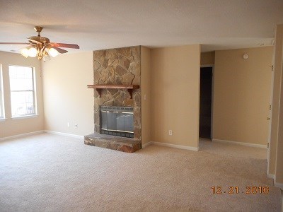 979 Old Cabaniss Road Forsyth, GA 31029 - Photo 10 of 33 an empty room with a fireplace and chandelier fan