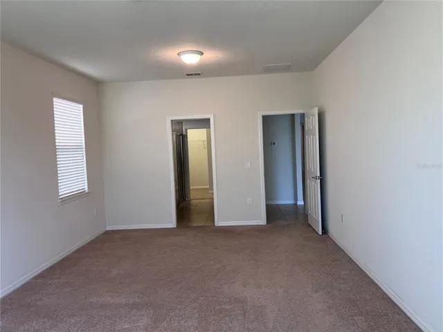 an empty room with windows and closet