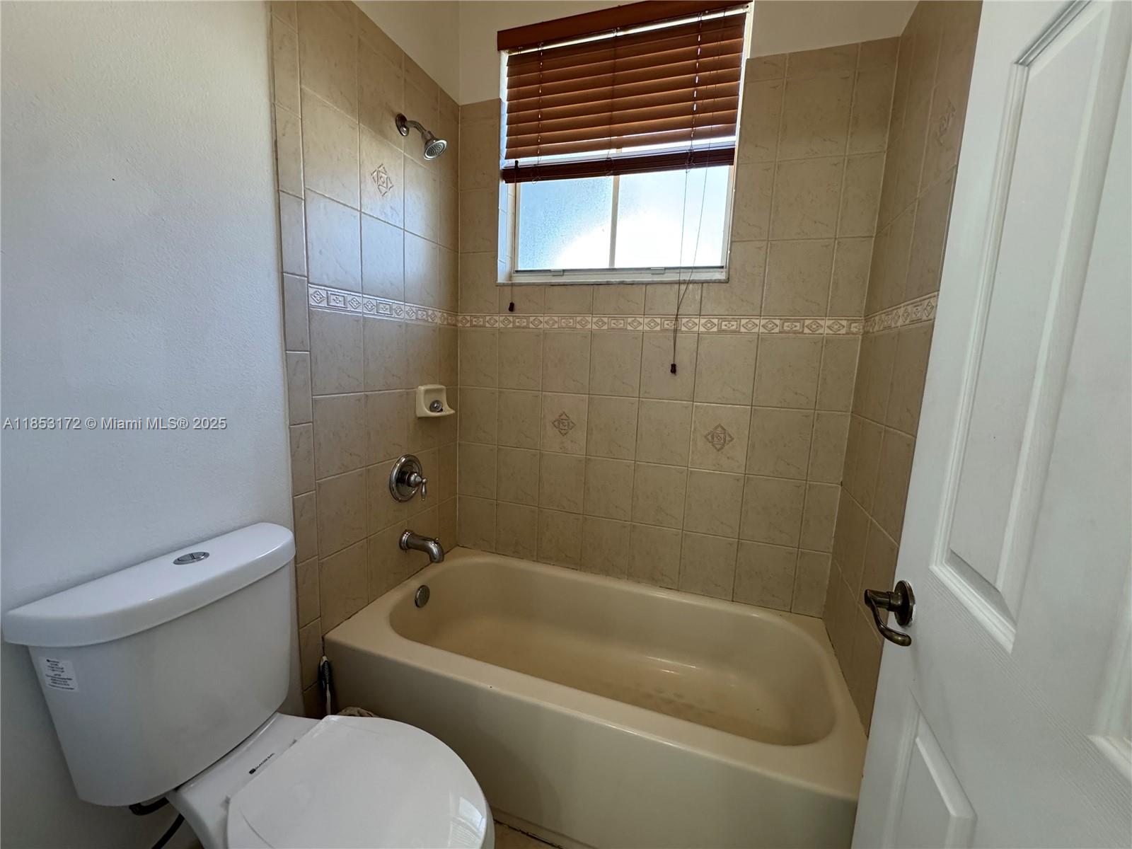 14046 Southwest 49th Street, Unit 16 Miramar, FL 33027 - Photo 12 of 22 a bathroom with a toilet and bathtub