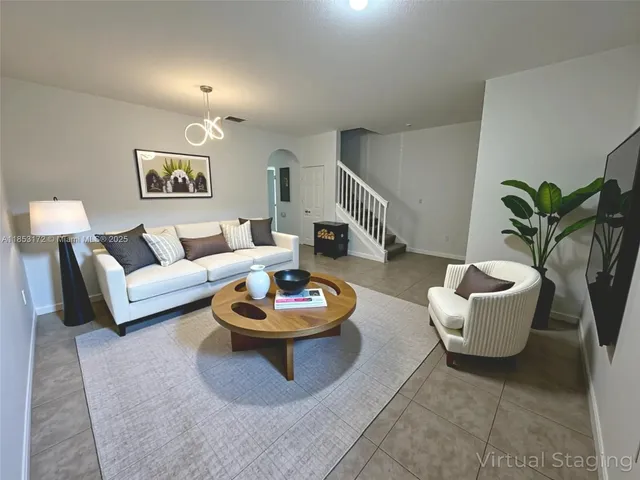 a living room with furniture and a potted plant