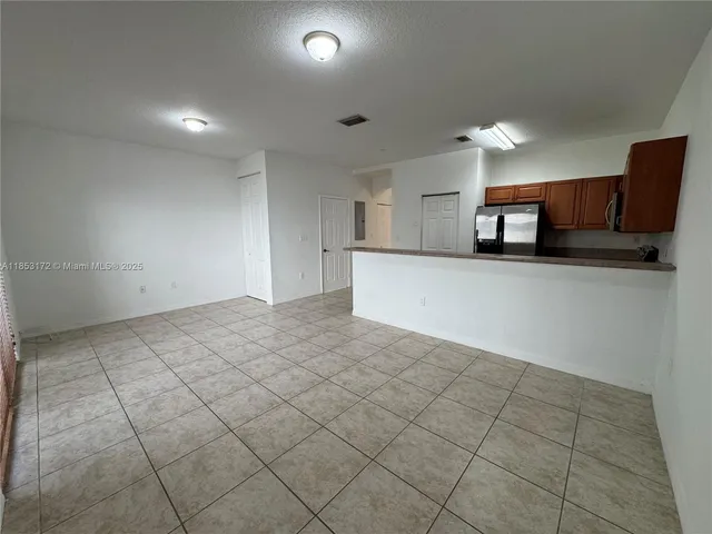 a view of a kitchen with a sink and a refrigerator