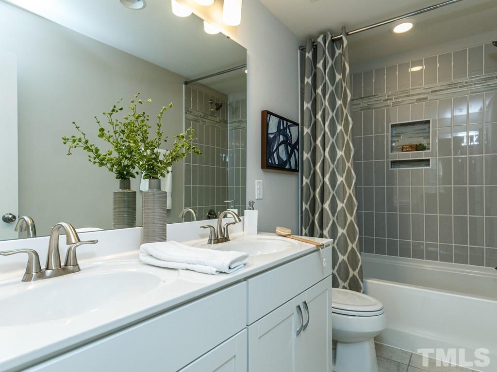 a bathroom with a sink a toilet a mirror a vanity and shower
