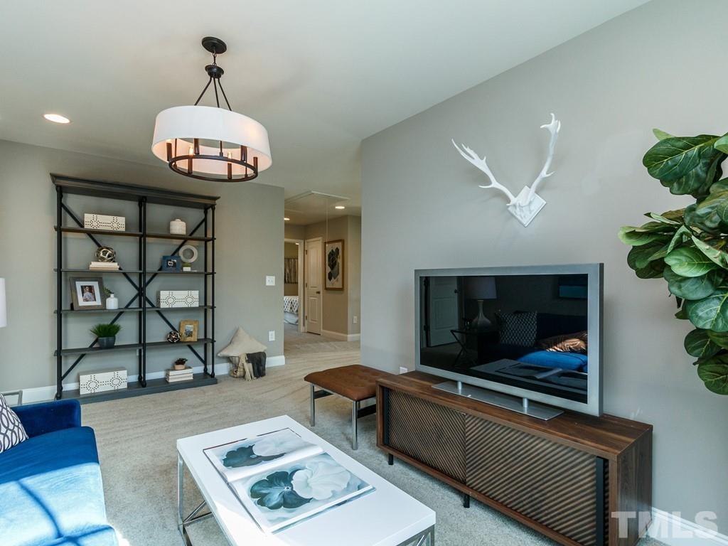 204 Kentigern Drive, Unit 34 Raleigh, NC 27606 - Photo 31 of 33 a living room with furniture a flat screen tv and kitchen view