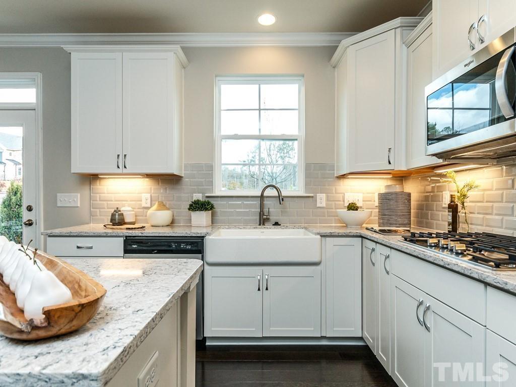 204 Kentigern Drive, Unit 34 Raleigh, NC 27606 - Photo 32 of 33 a kitchen with granite countertop white cabinets and white appliances