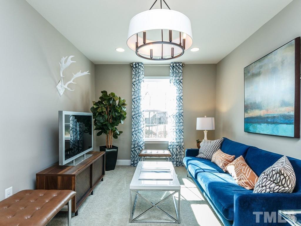 204 Kentigern Drive, Unit 34 Raleigh, NC 27606 - Photo 33 of 33 a living room with furniture chandelier and a flat screen tv