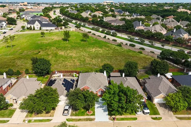 an aerial view of residential houses with outdoor space and trees all around