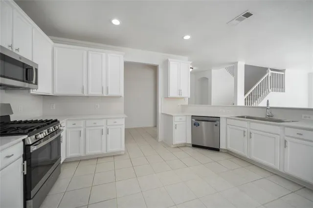 a large kitchen with a stove top oven and sink