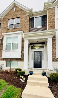 a front view of a house with plants