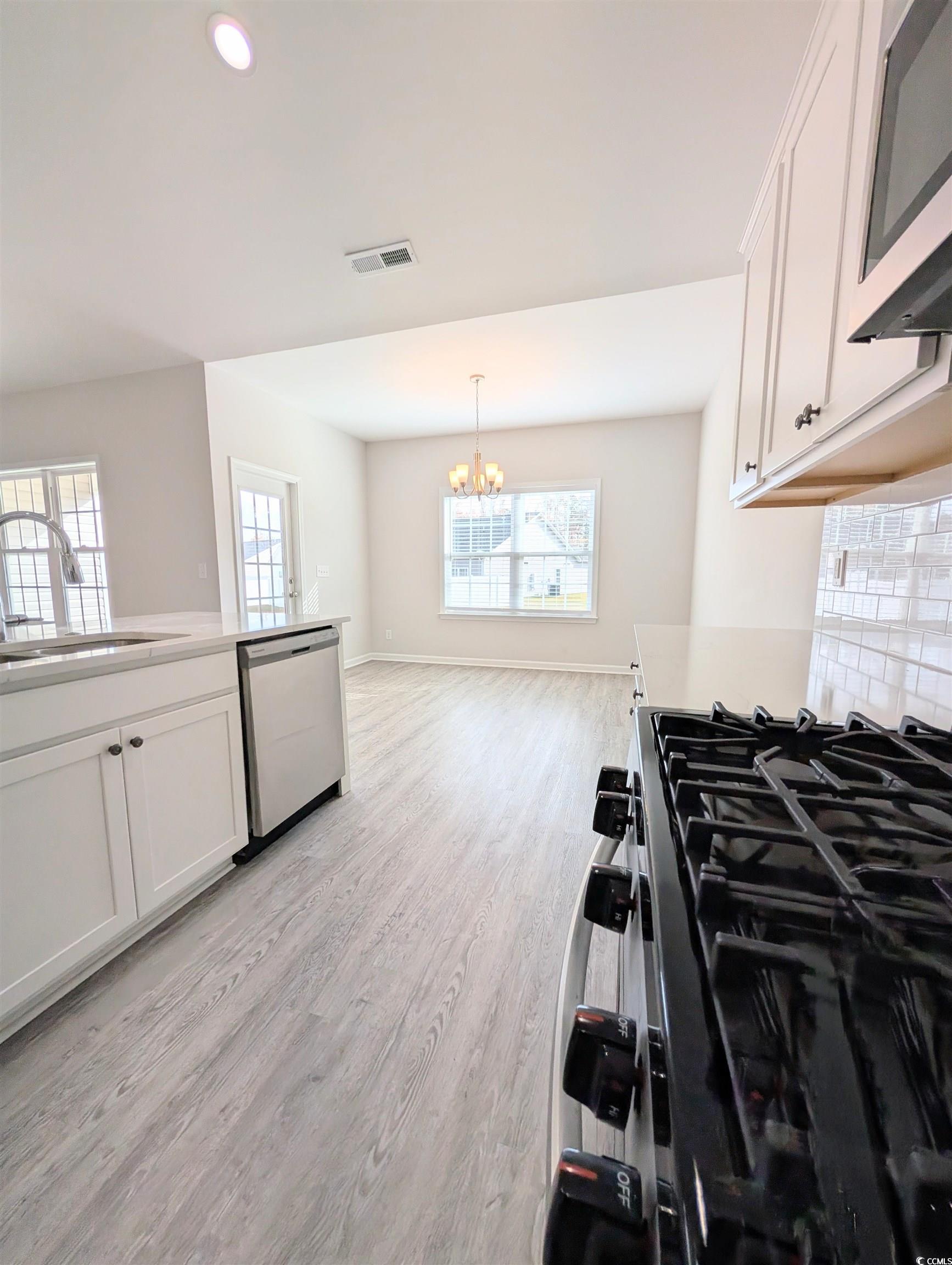 351 Lakota Loop Longs, SC 29568 - Photo 15 of 31 Kitchen featuring white cabinetry, appliances with stainless steel finishes, recessed lighting, light wood-type flooring, and a chandelier