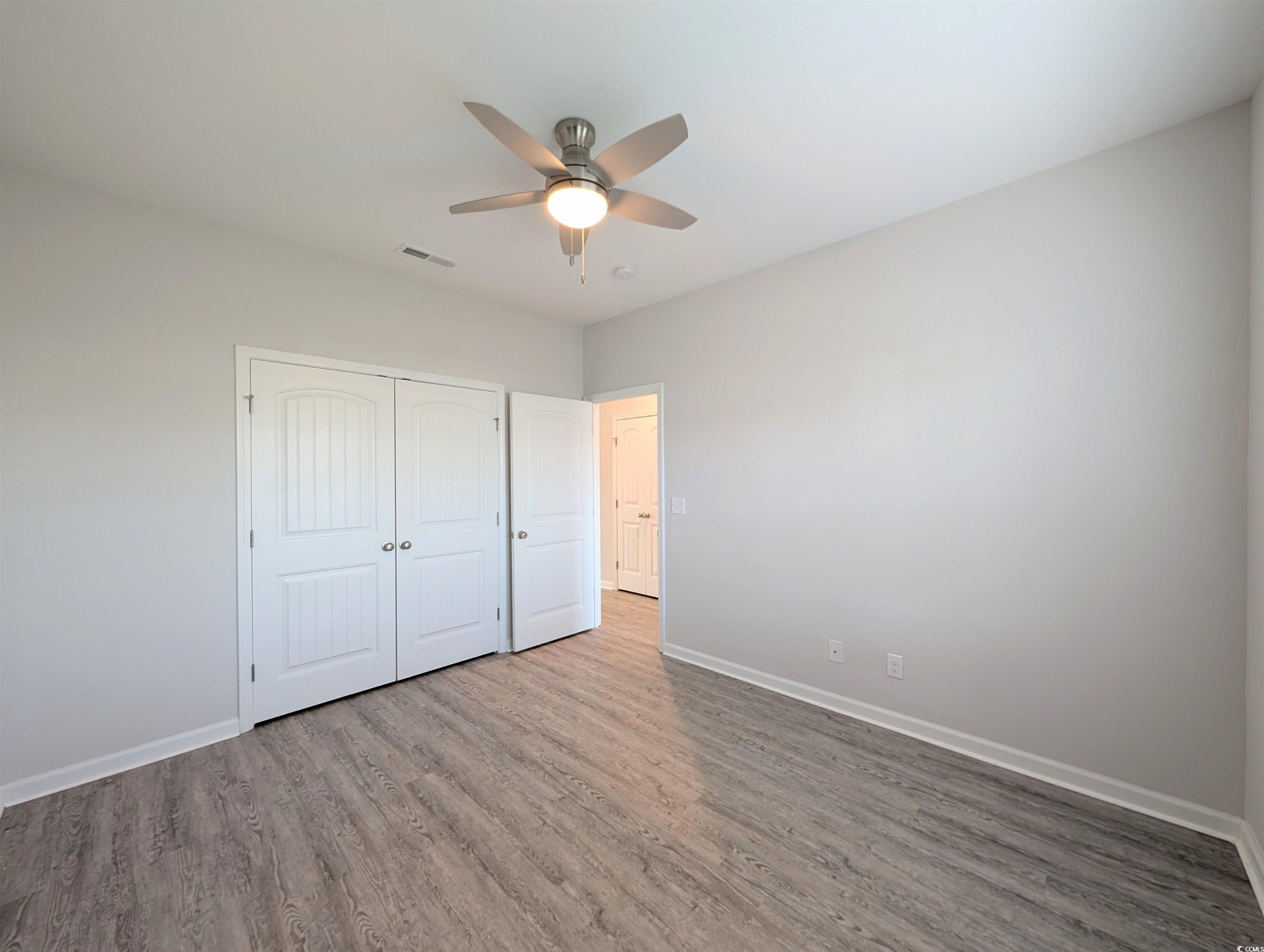 351 Lakota Loop Longs, SC 29568 - Photo 17 of 31 Unfurnished bedroom with wood finished floors, ceiling fan, and a closet