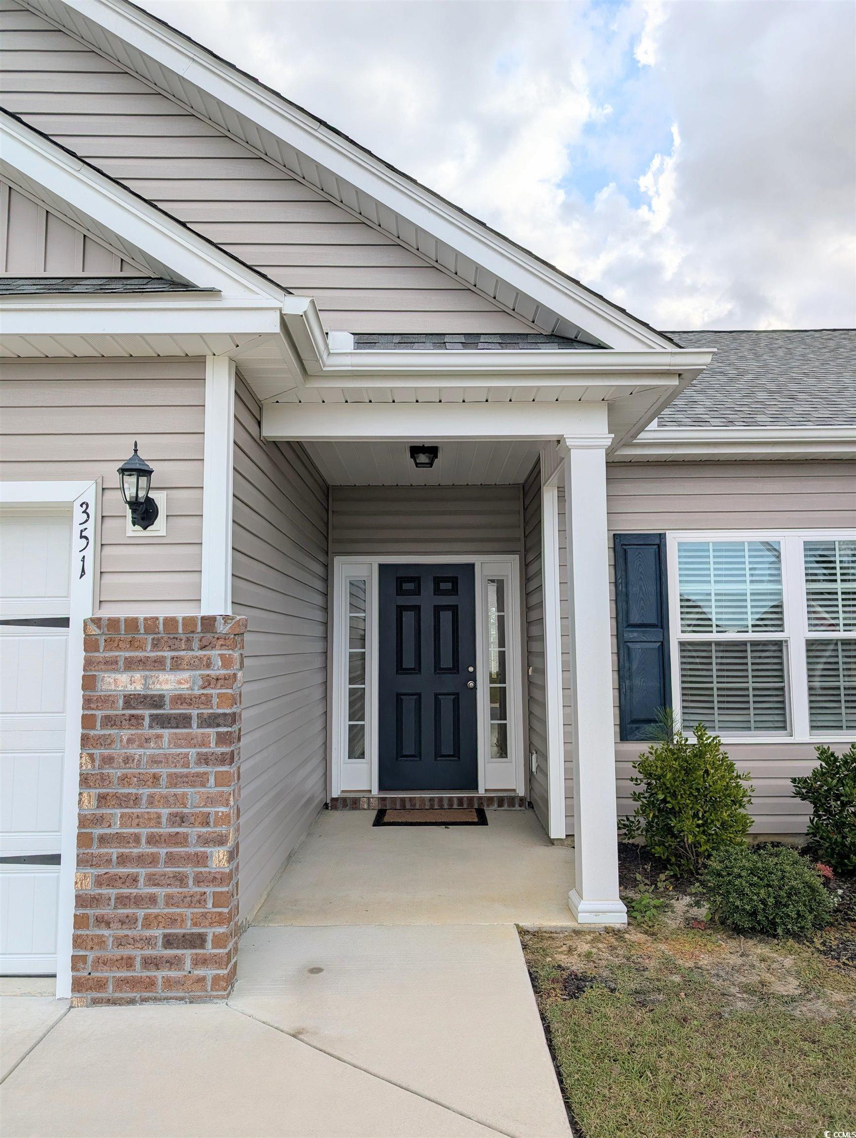 351 Lakota Loop Longs, SC 29568 - Photo 3 of 31 Entrance to property featuring covered porch, a garage, and a shingled roof