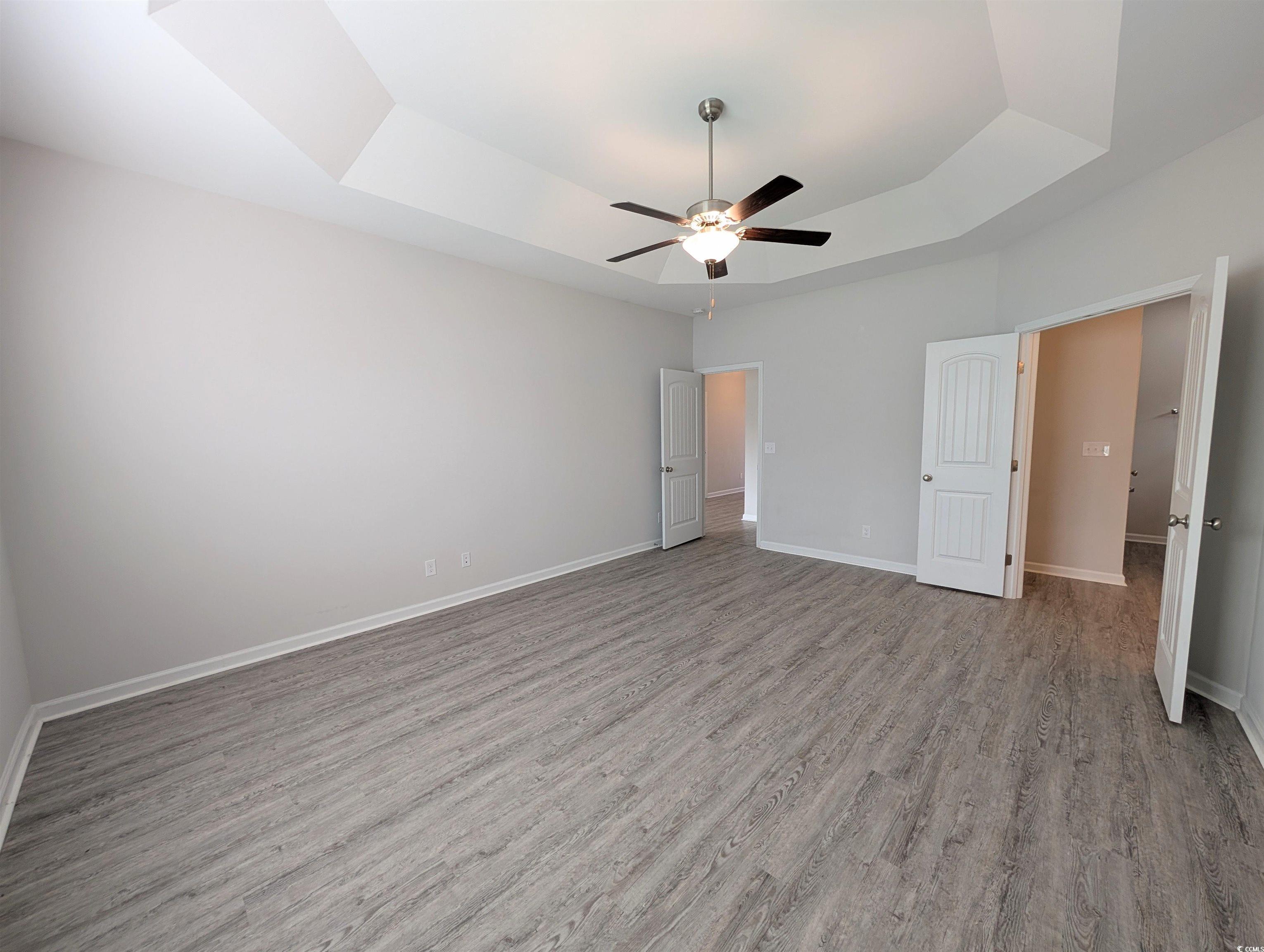 351 Lakota Loop Longs, SC 29568 - Photo 9 of 31 Unfurnished bedroom featuring a raised ceiling, light wood finished floors, and ceiling fan