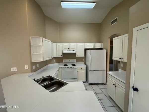 a kitchen with white cabinets appliances and a sink