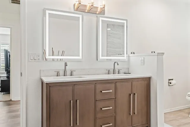 a bathroom with a granite countertop sink vanity and mirror
