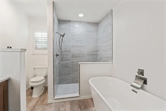 a bathroom with a white bath tub a toilet and a sink