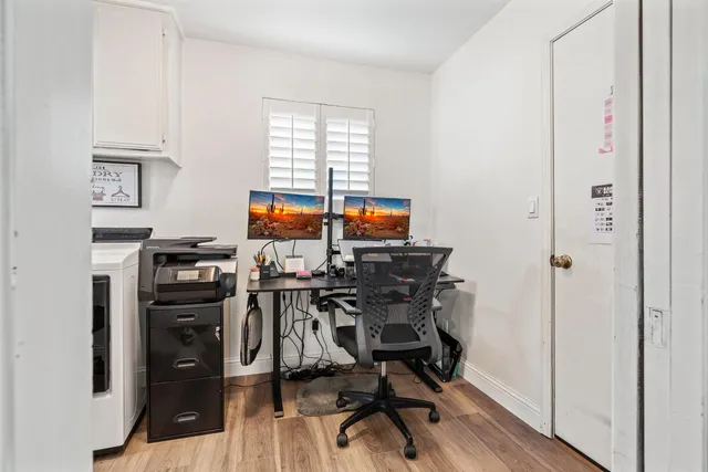 a view of a workspace with furniture and wooden floor
