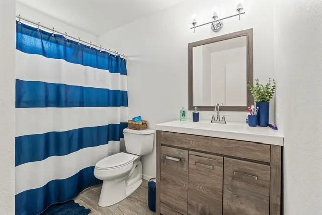 a bathroom with a toilet a sink and a mirror