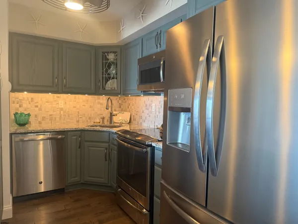 a kitchen with stainless steel appliances granite countertop a sink stove and refrigerator