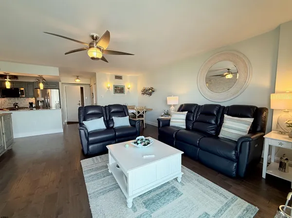 a living room with furniture a rug and wooden floor