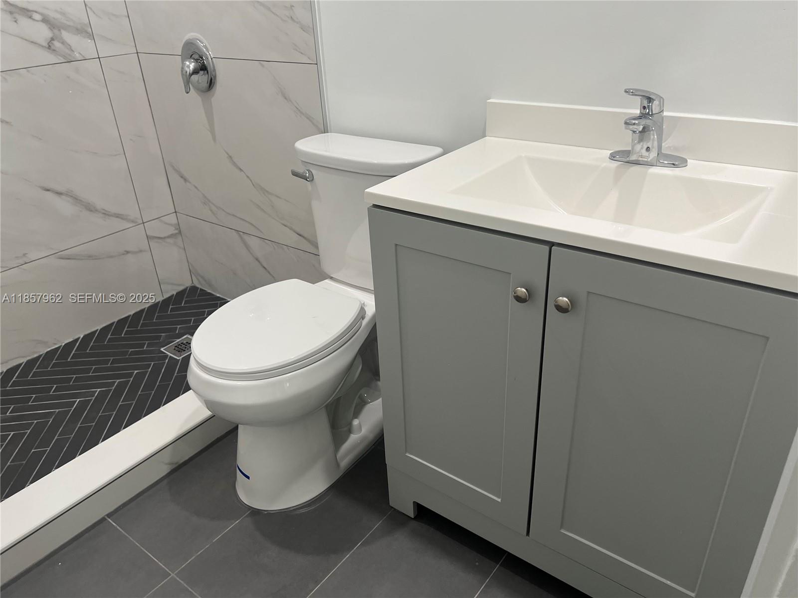 832 Northeast 5th Avenue, Unit 832 Homestead, FL 33030 - Photo 14 of 15 a bathroom with a sink toilet and shower