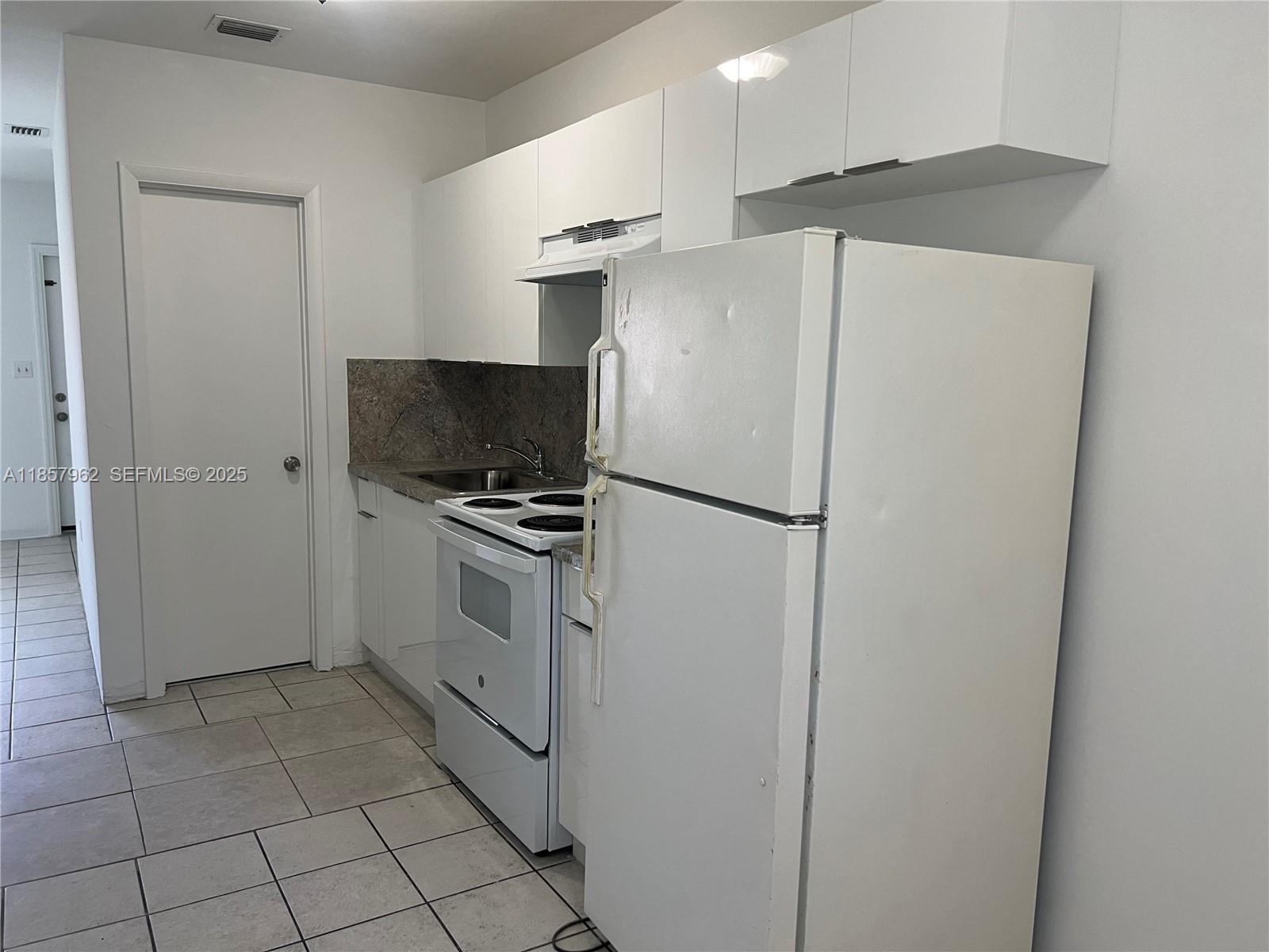 832 Northeast 5th Avenue, Unit 832 Homestead, FL 33030 - Photo 8 of 15 a kitchen with stainless steel appliances a refrigerator a stove a microwave and a sink