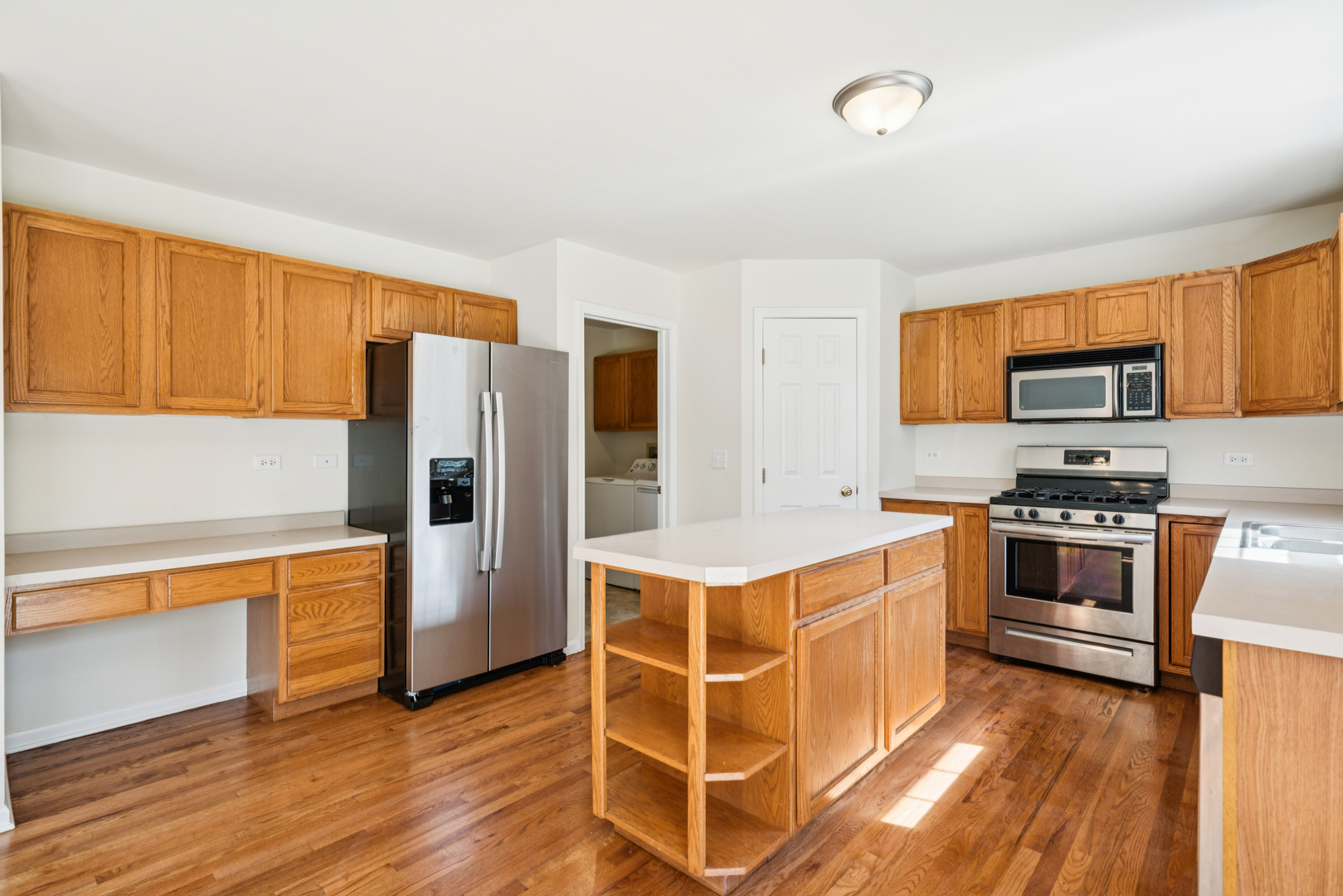 11683 Joan Avenue Huntley, IL 60142 - Photo 7 of 21 a kitchen with stainless steel appliances a stove a refrigerator cabinets and wooden floor