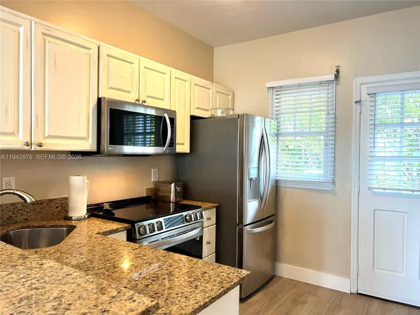 a kitchen with cabinets stainless steel appliances and a counter space