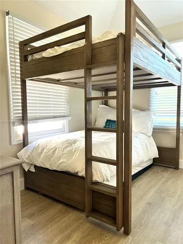 a bedroom with a bed and wooden floor