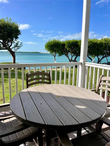 a living room with furniture kitchen view and a wooden floor