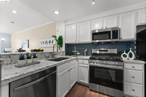 a kitchen with stainless steel appliances granite countertop a sink a stove and a granite counter tops