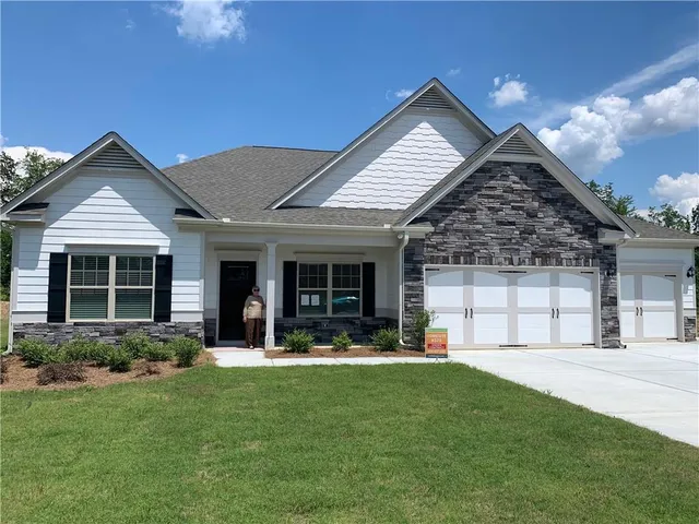 a front view of a house with a yard and outdoor seating