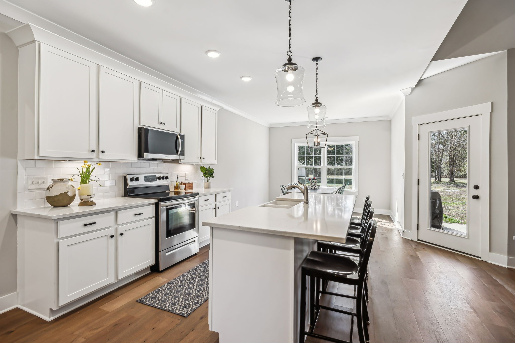 1567 Harrison Road Murfreesboro, TN 37128 - Photo 16 of 56 a kitchen with kitchen island granite countertop a stove a sink a dining table and chairs