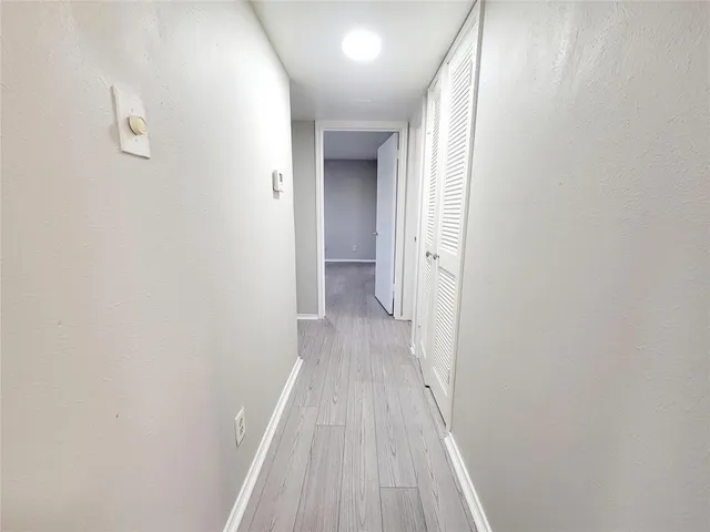 a view of a room with wooden floor and a hallway