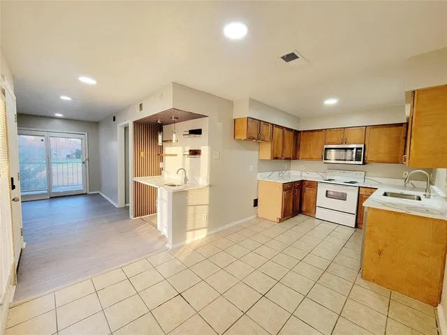a kitchen with stainless steel appliances a refrigerator and a stove top oven