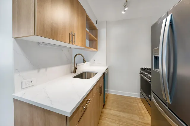 a kitchen with stainless steel appliances a sink a stove and a refrigerator