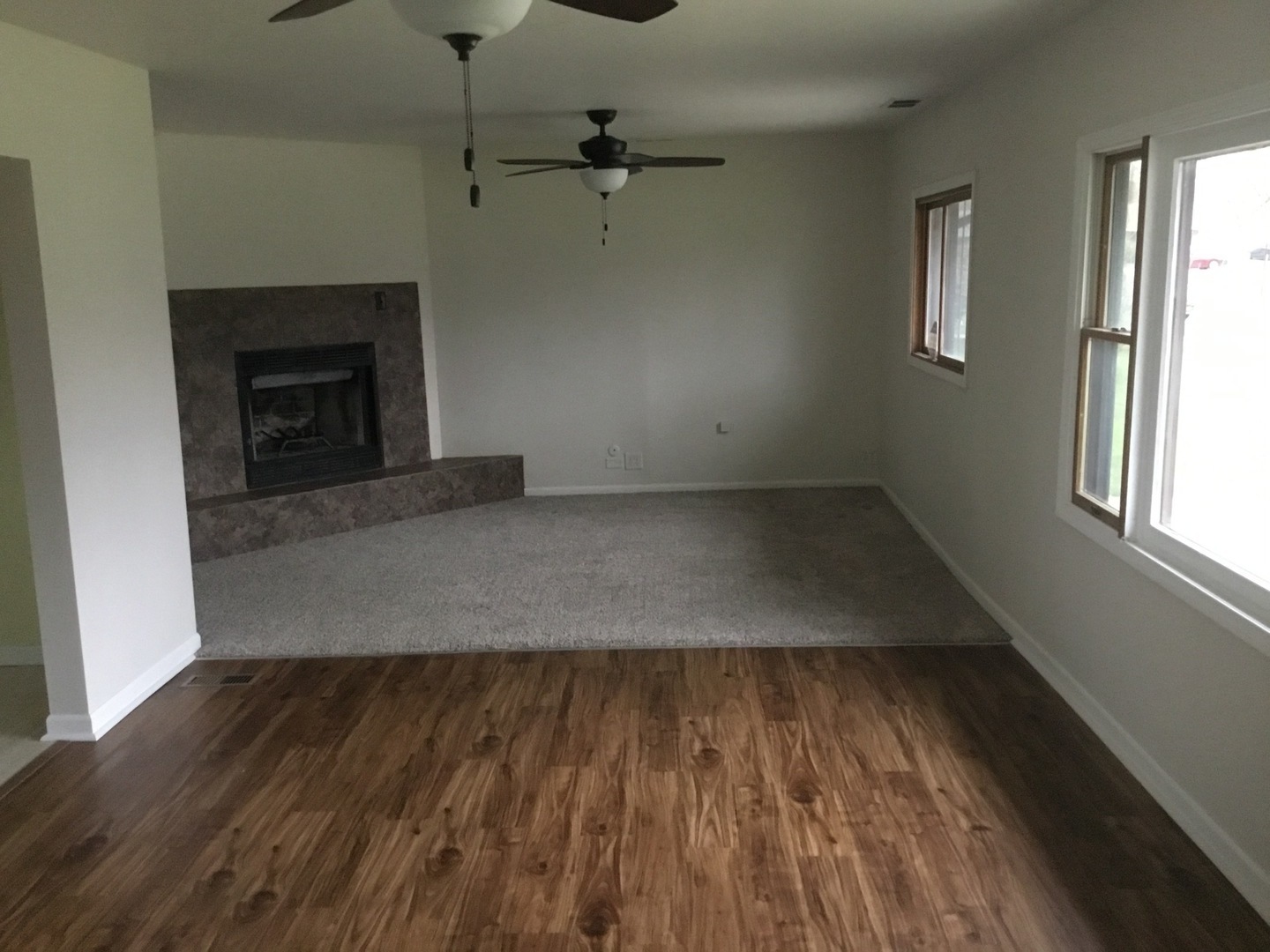 Undisclosed Address Richton Park, IL 60471 - Photo 2 of 11 an empty room with wooden floor a fireplace and windows
