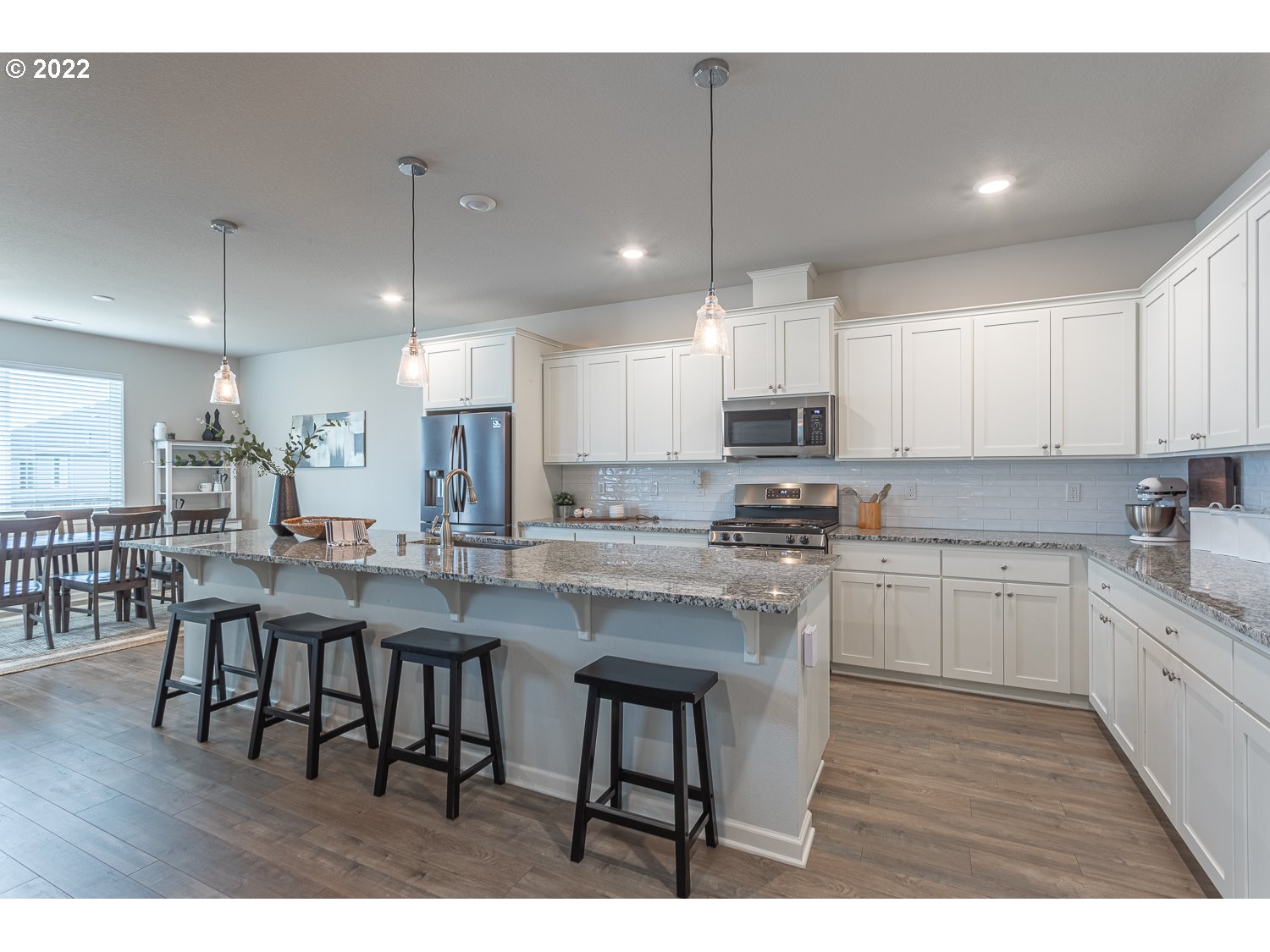 3821 South 41st Place Ridgefield, WA 98642 - Photo 8 of 32 a kitchen with stainless steel appliances granite countertop a table chairs sink refrigerator and cabinets