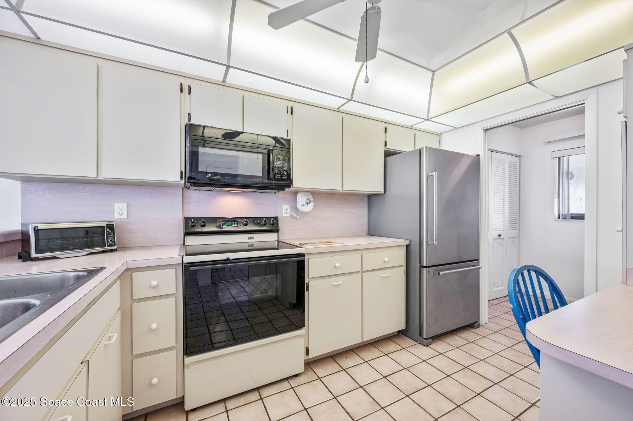 200 South Banana River Boulevard, Unit 2424 Cocoa Beach, FL 32931 - Photo 5 of 18 a kitchen with cabinets stainless steel appliances and a counter space