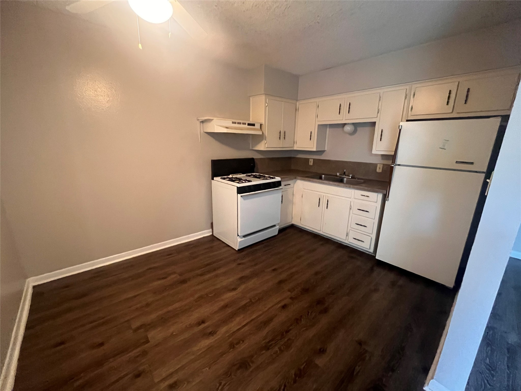 3106 Duval Street, Unit 306 Austin, TX 78705 - Photo 3 of 12 a kitchen with a sink a refrigerator and white cabinets