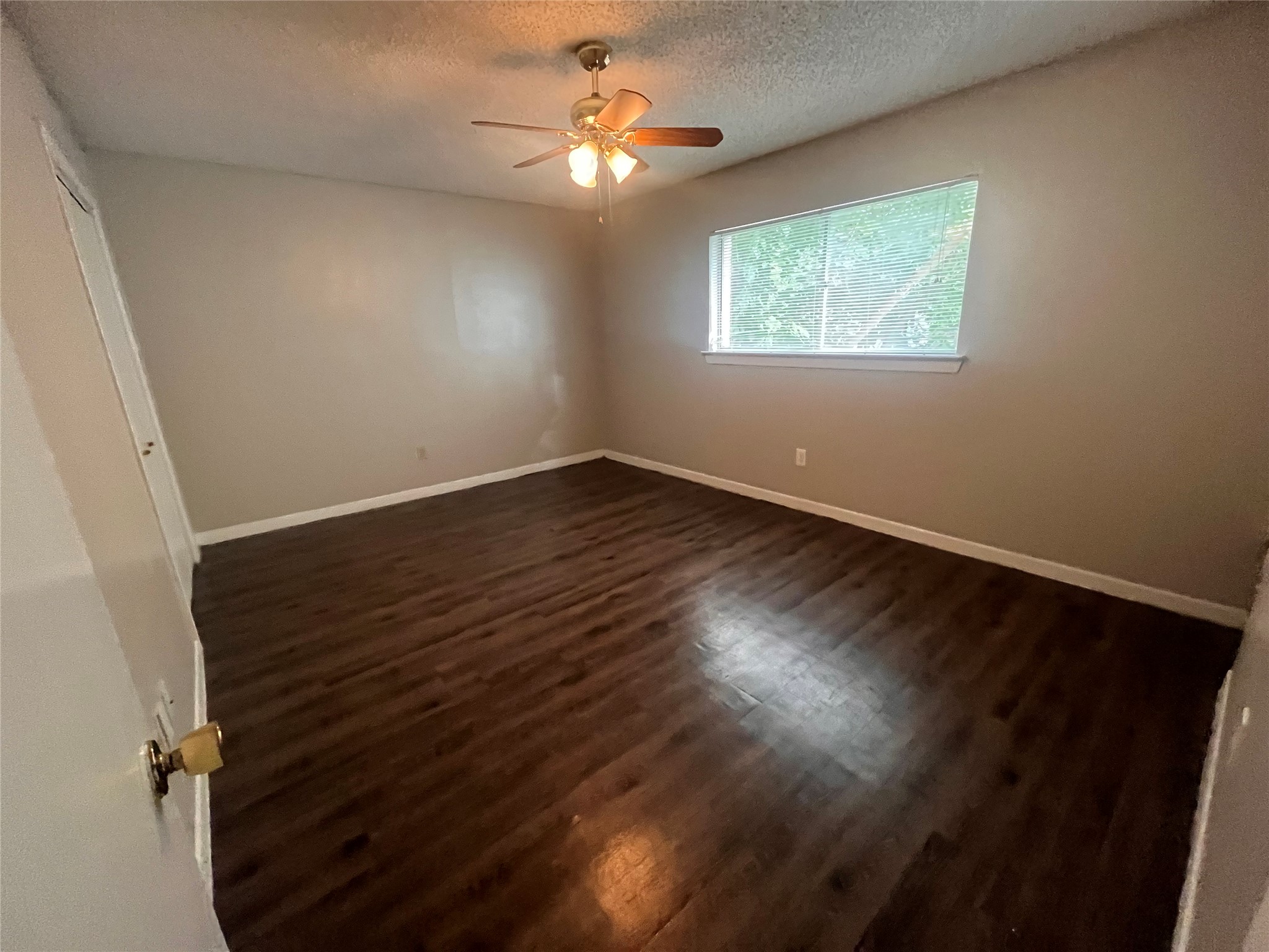 3106 Duval Street, Unit 306 Austin, TX 78705 - Photo 4 of 12 an empty room with wooden floor chandelier fan and windows