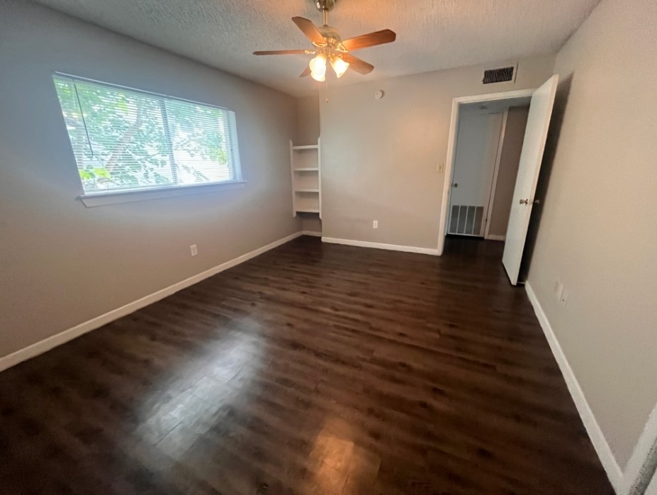 3106 Duval Street, Unit 306 Austin, TX 78705 - Photo 5 of 12 a view of an empty room with wooden floor and a window