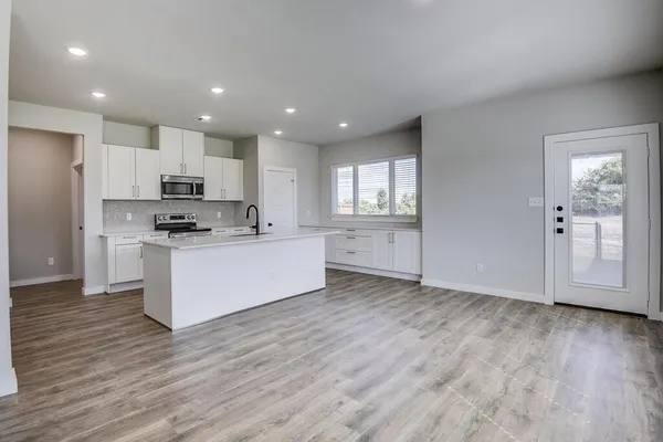 a kitchen with stainless steel appliances granite countertop a sink stove and refrigerator