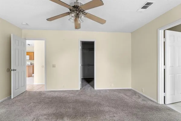 an empty room with closet and a chandelier fan