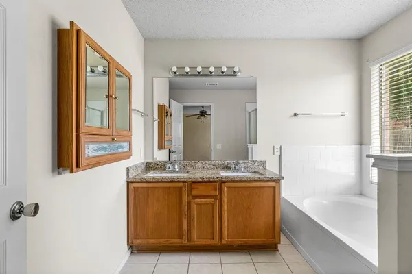 a bathroom with a granite countertop sink a mirror and a bathtub