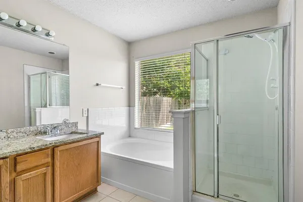 a bathroom with a granite countertop sink and a bathtub