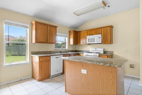 a kitchen with granite countertop cabinets stainless steel appliances a sink and a window